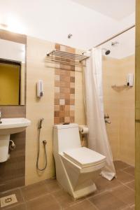 a bathroom with a toilet and a sink at Angson Apartment in Chennai