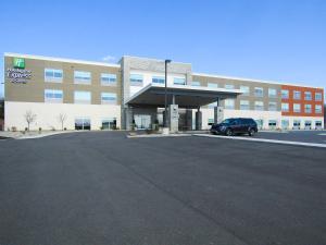 une voiture garée dans un parking en face d'un bâtiment dans l'établissement Holiday Inn Express & Suites Coldwater, an IHG Hotel, à Coldwater