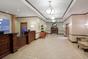 a man standing at a reception desk in a hospital lobby at Holiday Inn Express & Suites Buffalo, an IHG Hotel in Buffalo