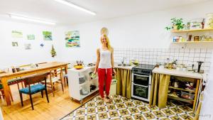 a woman standing in a kitchen next to a stove at Tree House in Riga