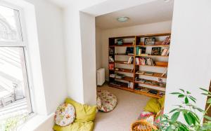ein Wohnzimmer mit Fenster und Bücherregal in der Unterkunft Tree House in Riga