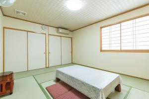 Sakura的住宿－Tabist Matsushima Onsen Otomenoyu Sakurashi，一间带床的卧室,位于带窗户的房间内