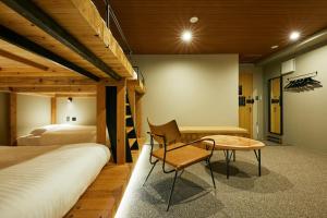 una camera con 2 letti a castello, una scrivania e un tavolo di mizuka Daimyo 7 - unmanned hotel - a Fukuoka