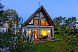 a small white house with a roof at Lotsenstieg 03 in Ostseebad Karlshagen