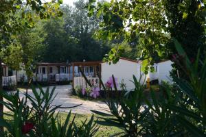 a row of mobile homes in a yard with flowers at Campeggio Falconera in Caorle