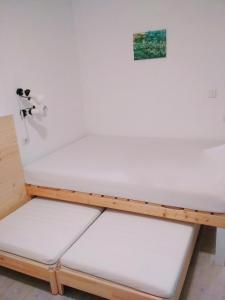 Bett in einem Zimmer mit weißer Bettwäsche in der Unterkunft Pokljuka Triglav national park in Zgornje Gorje