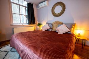 1 dormitorio con 1 cama grande y espejo en la pared en Bambu Sleep Boutique, en Haarlem