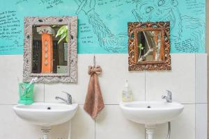 a bathroom with two sinks and mirrors on the wall at Padi-Padi Hostel & Bar in Ubud