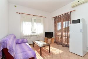 a living room with a chair and a refrigerator at Apartments Edin 1359 in Peroj