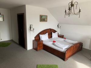 Un dormitorio con una gran cama de madera con almohadas blancas. en Pension La Noblesse, en Bucarest