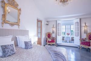 sypialnia z dużym łóżkiem i 2 krzesłami w obiekcie Casa Nova Estate w mieście Sitges