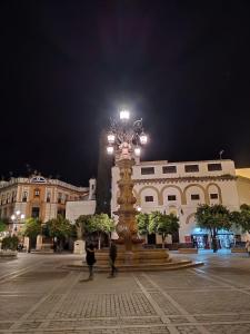 einen Uhrturm mitten auf einem Platz in der Nacht in der Unterkunft Living Triana House in Sevilla