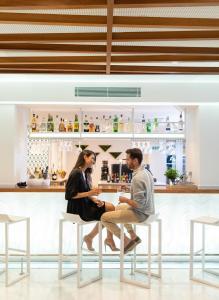 a man and woman sitting at a table in a bar at JS Yate in Can Picafort