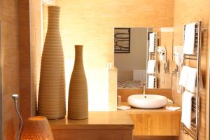 two vases sitting on a counter in a bathroom at Hotel Le Bellevue, Demeures & Chateaux in Villerville +35 photos