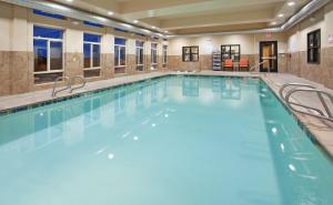 duży kryty basen z niebieską wodą w budynku w obiekcie Holiday Inn Express & Suites Gallup East, an IHG Hotel w mieście Gallup