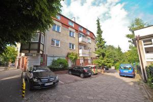two cars parked in a parking lot next to a building at Aparment near Monte Cassino by Grand Apartments in Sopot