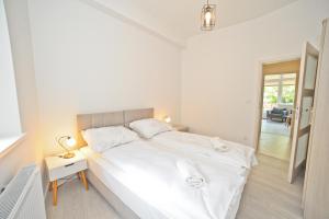 a bedroom with a large white bed and a table at Aparment near Monte Cassino by Grand Apartments in Sopot