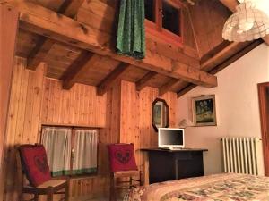 a bedroom with a bed and a tv and chairs at Locanda Farinati in Abetone