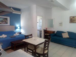 a living room with a blue couch and a table at Cristal Studios in Z&oacute;la