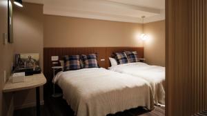 a bedroom with two beds and a table with a mirror at miss morgan hotel in Hiratsuka