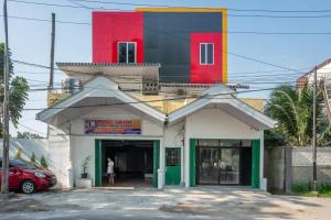 a building with a red and black tower on top at RedDoorz near Manhattan Times Square Medan 2 in Medan