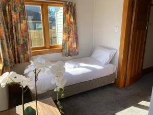uma pequena cama num quarto com uma janela em Knights rd beauty em Lower Hutt