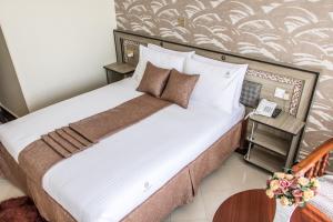 Postel nebo postele na pokoji v ubytování Astorian Grand Hotel Naivasha
