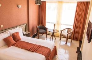 Postel nebo postele na pokoji v ubytování Astorian Grand Hotel Naivasha