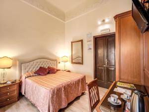 a bedroom with a bed and a dresser and a table at Hotel Labelle in Rome