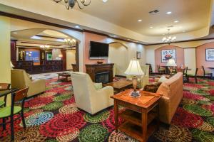 uma sala de estar com um sofá e cadeiras e uma televisão em Holiday Inn Express Hotel & Suites Terrell, an IHG Hotel em Terrell