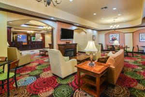 a living room with a couch and chairs and a television at Holiday Inn Express Hotel & Suites Terrell, an IHG Hotel in Terrell