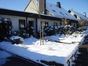 a house with snow on the ground in front of it at WenneGlück in Meschede