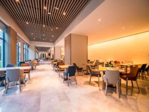 - une salle à manger avec des tables, des chaises et des fenêtres dans l'établissement Holiday Inn Express Kunming West, an IHG Hotel, à Kunming