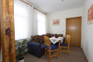 a room with a table and chairs and a couch at Pension Thaler Hof in Thale