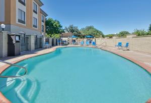 una grande piscina con sedie e un edificio di Holiday Inn Express & Suites Dallas - Duncanville, an IHG Hotel a Duncanville