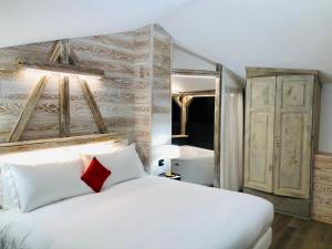 a bedroom with a white bed with a red pillow at Hotel Alla Posta in Saint Vincent +89 photos
