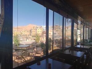 ein Restaurant mit Tischen und Stühlen und Stadtblick in der Unterkunft Petra Visitors Apartments in Wadi Musa