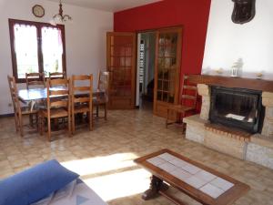 a living room with a table and a fireplace at Jolie maison de campagne in Lainsecq