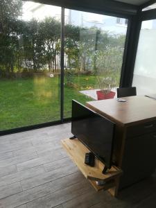 an office with a desk with a tv and a window at La KLEMALINE in Pessac