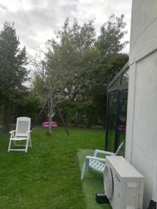 einen Hof mit zwei Stühlen und einem Computer auf dem Rasen in der Unterkunft La KLEMALINE in Pessac