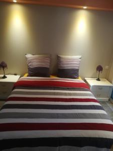 ein Schlafzimmer mit einem Bett mit zwei Nachttischen in der Unterkunft La KLEMALINE in Pessac