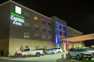 ein Hotel mit Autos auf einem Parkplatz in der Unterkunft Holiday Inn Express & Suites - Dayton Southwest, an IHG Hotel in Dayton