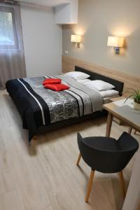 1 dormitorio con 1 cama, 1 silla y 1 mesa en Fotex, en Ząbki