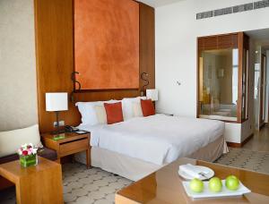 a hotel room with a large bed and a table at Yas Island Rotana Abu Dhabi in Abu Dhabi