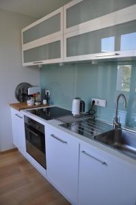 a kitchen with a sink and a stove top oven at apartments&co in Wolfsburg