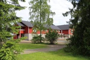 a red building with trees in front of it at Hotelli Niittyranta in Niittylahti