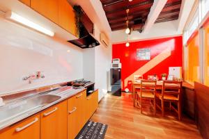 uma cozinha com paredes vermelhas e uma mesa com cadeiras em Terrace Terano#101 em Tóquio