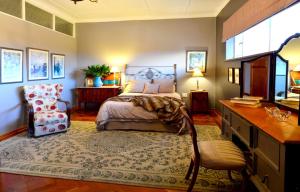 a bedroom with a bed and a desk and a chair at THE WHITE HOUSE in Johannesburg