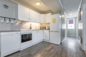 a kitchen with white cabinets and a wooden floor at Sagi 1 Privat Apartment in Hafslo