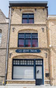 um edifício de tijolos com um sinal que diz le chart norte em LE CHAT NOIR em Ypres